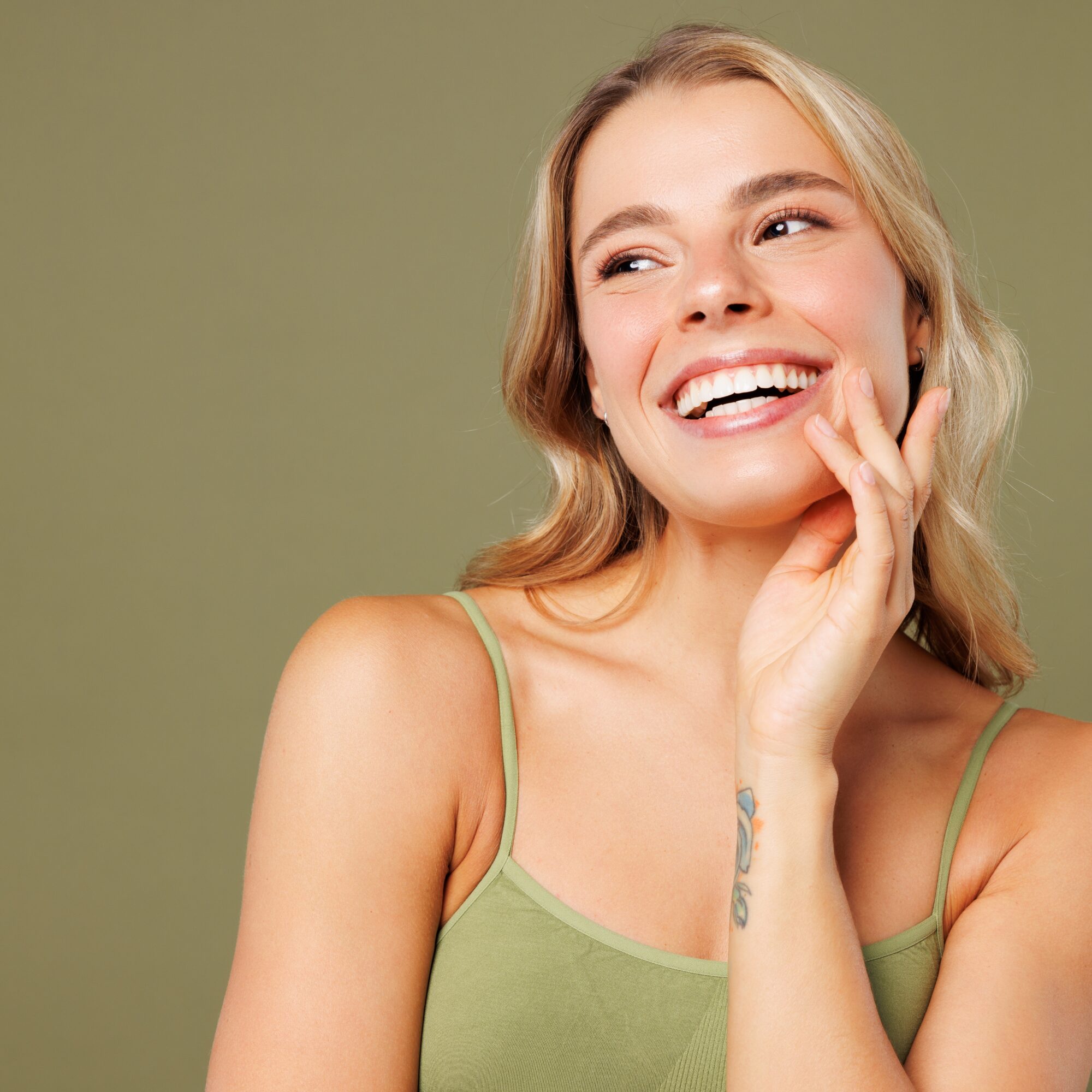 young woman smiling against a grey background