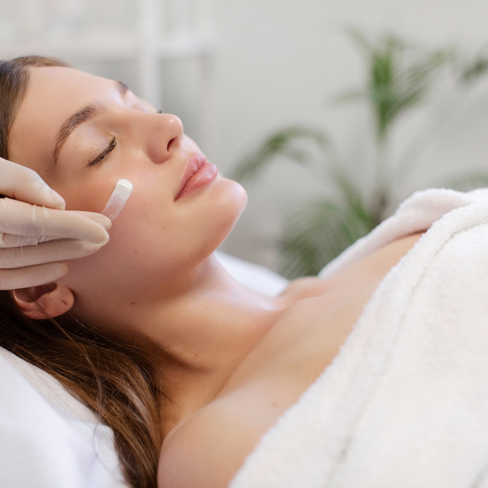 Lady receiving facial skincare treatment in beauty salon